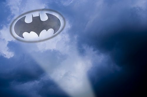 The Bat-Signal projected onto storm clouds