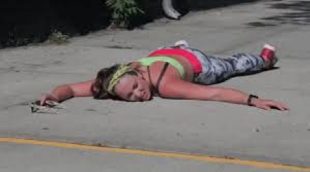 Runner lying face-down on the pavement during a race