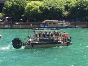 Small tour boat carrying passengers across teal-colored water