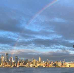 Rainbow arcing over a city skyline and waterfront